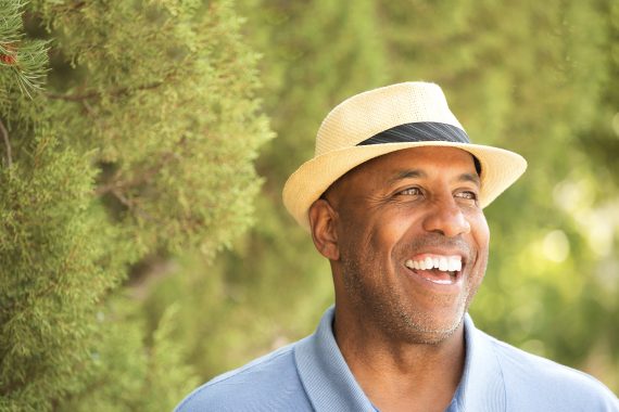 Smiling man with tweed hat.