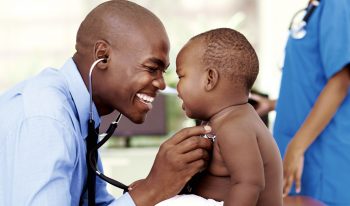 Clinician checking a small child's heart beat with a stethoscope