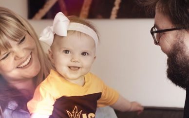 Happy family with small child wearing ASU colors