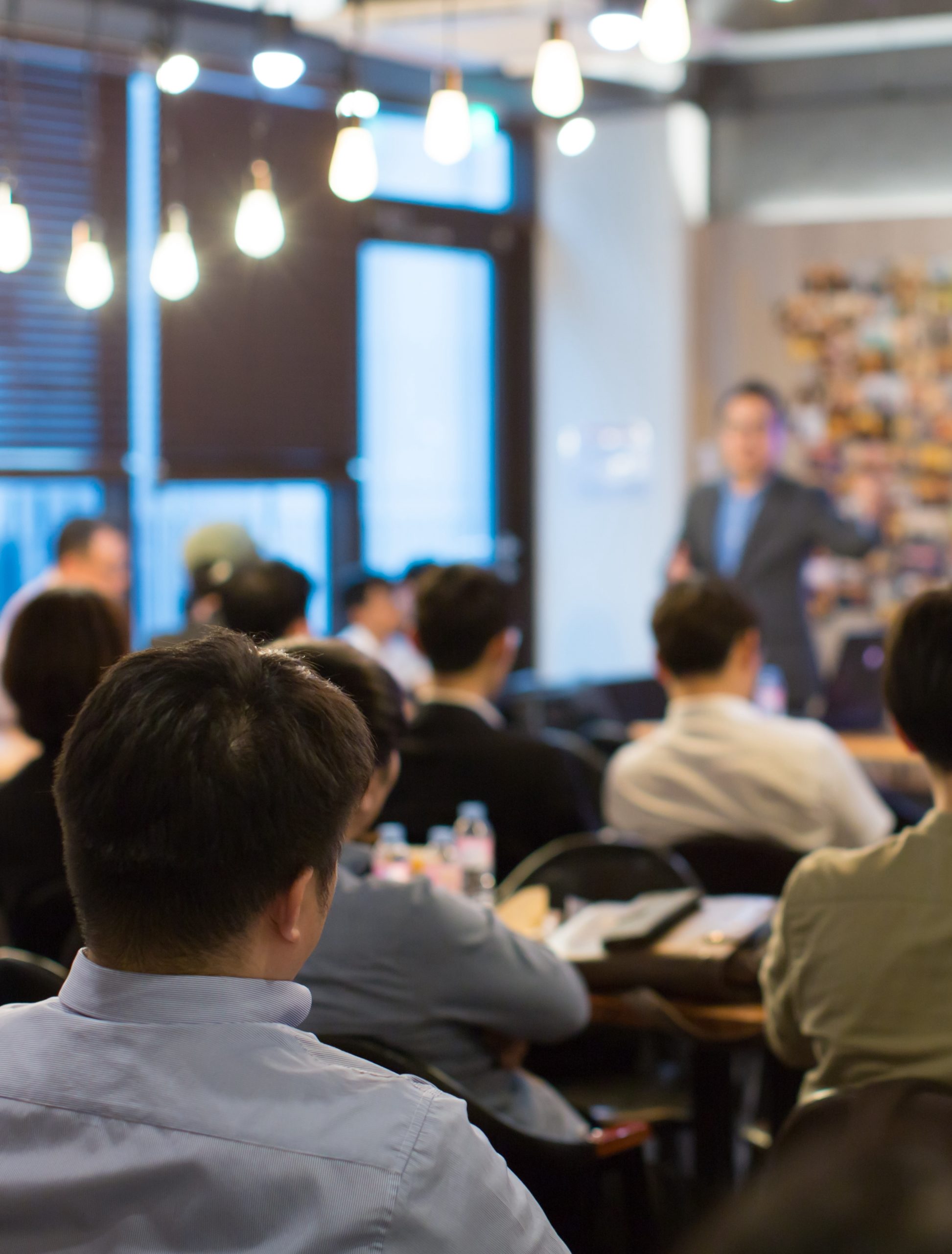 Audience Listens to Lecturer at a Conference Meeting Seminar Training. Group of People Hear Presenter Give Speech . Corporate Manager Speaker Gives Business Technology and Economic Forecast.